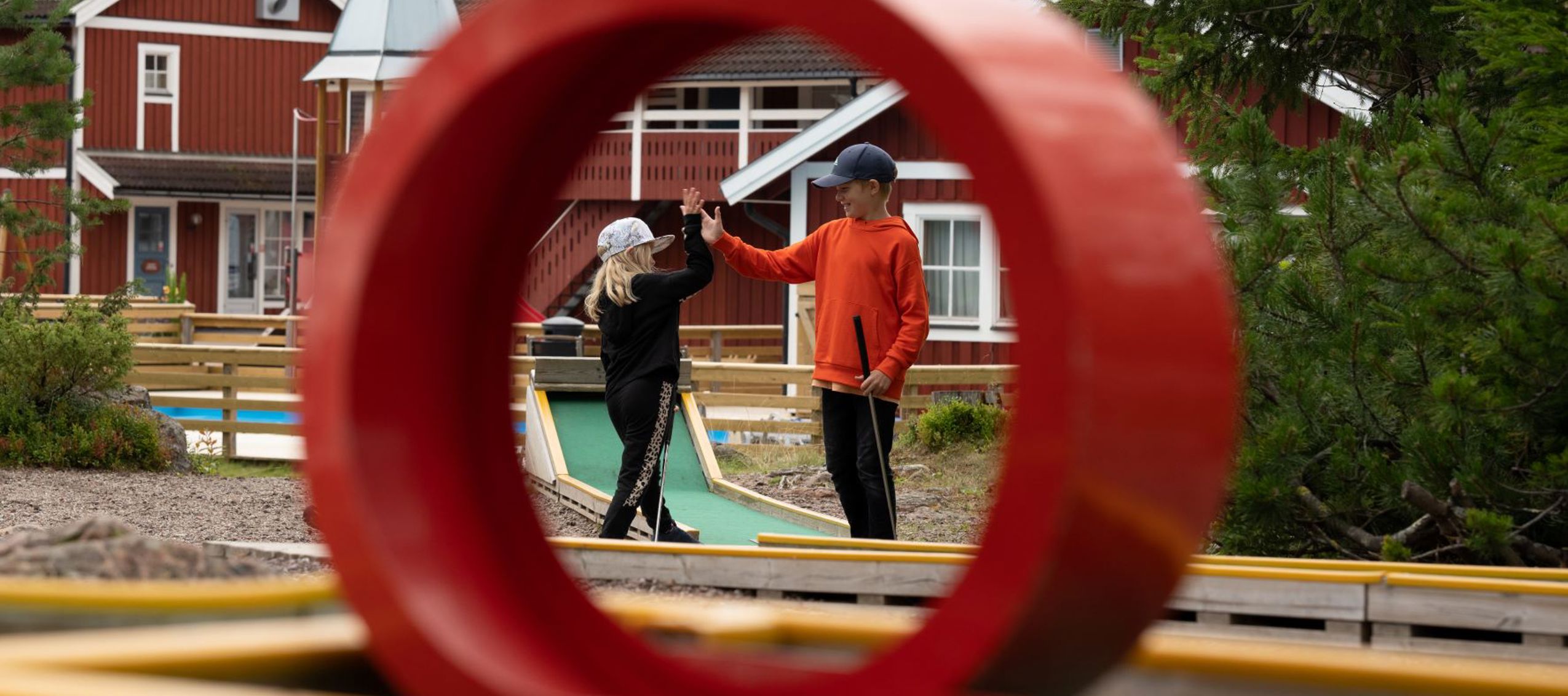High five under minigolfspel - två barn leker glatt i Orsa Grönklitt.